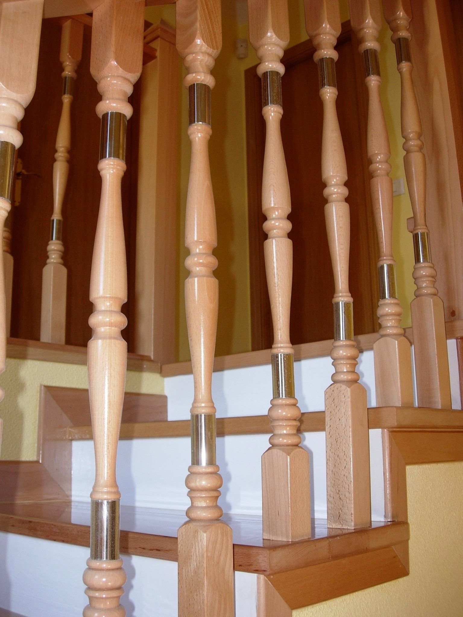 Un conjunto de escaleras de madera con barandilla de metal.