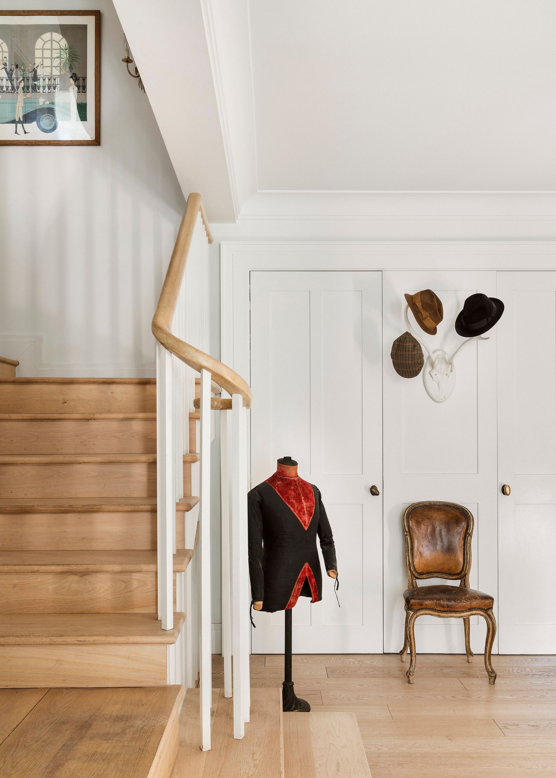 Una escalera de madera con un maniquí delante de ella.