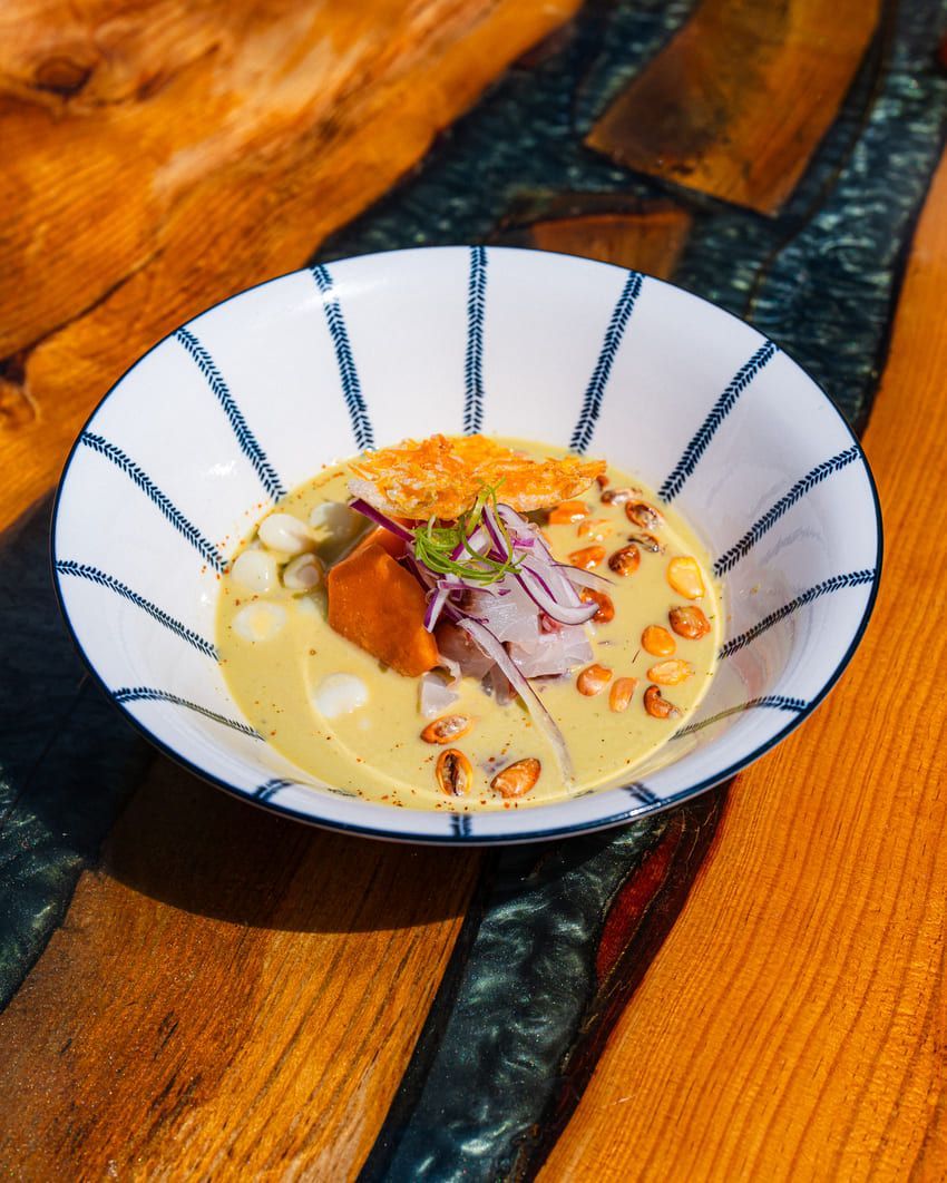 Un plato blanco cubierto con almejas y perejil sobre una mesa.