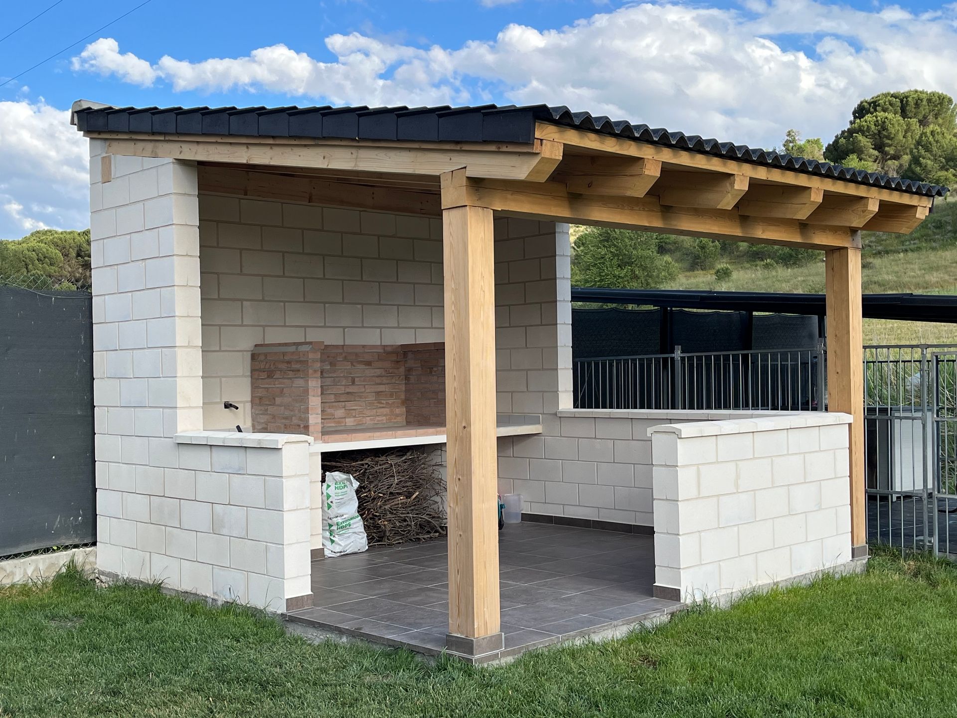Un pequeño edificio de ladrillo blanco con techo de madera.