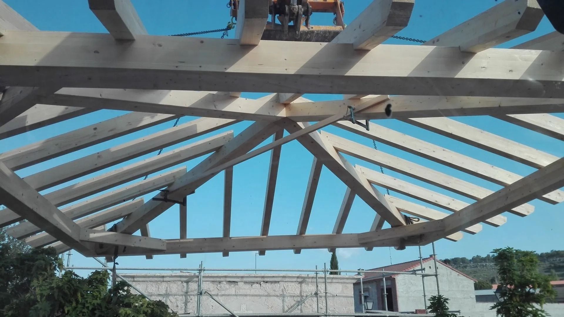 Una estructura de madera con un cielo azul al fondo.