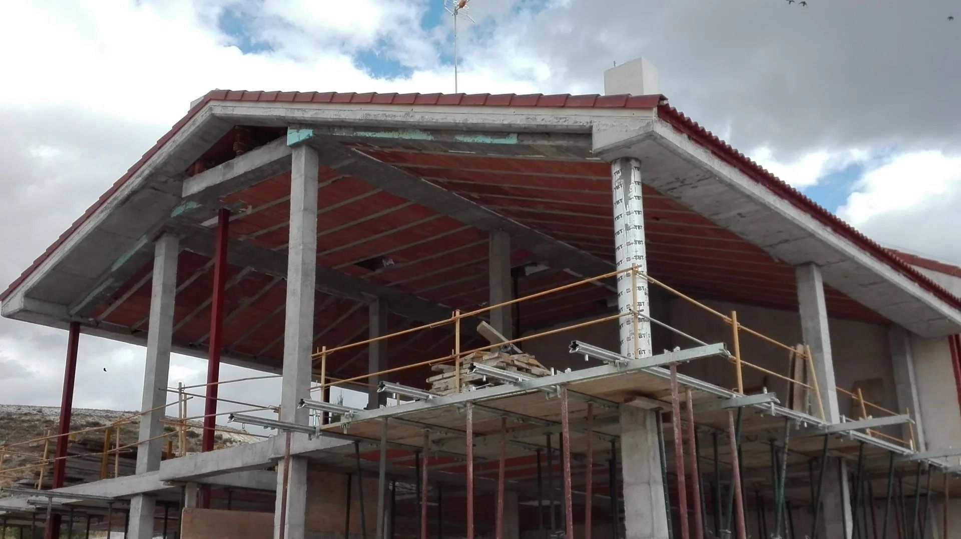 Un edificio en construcción con techo de tejas rojas