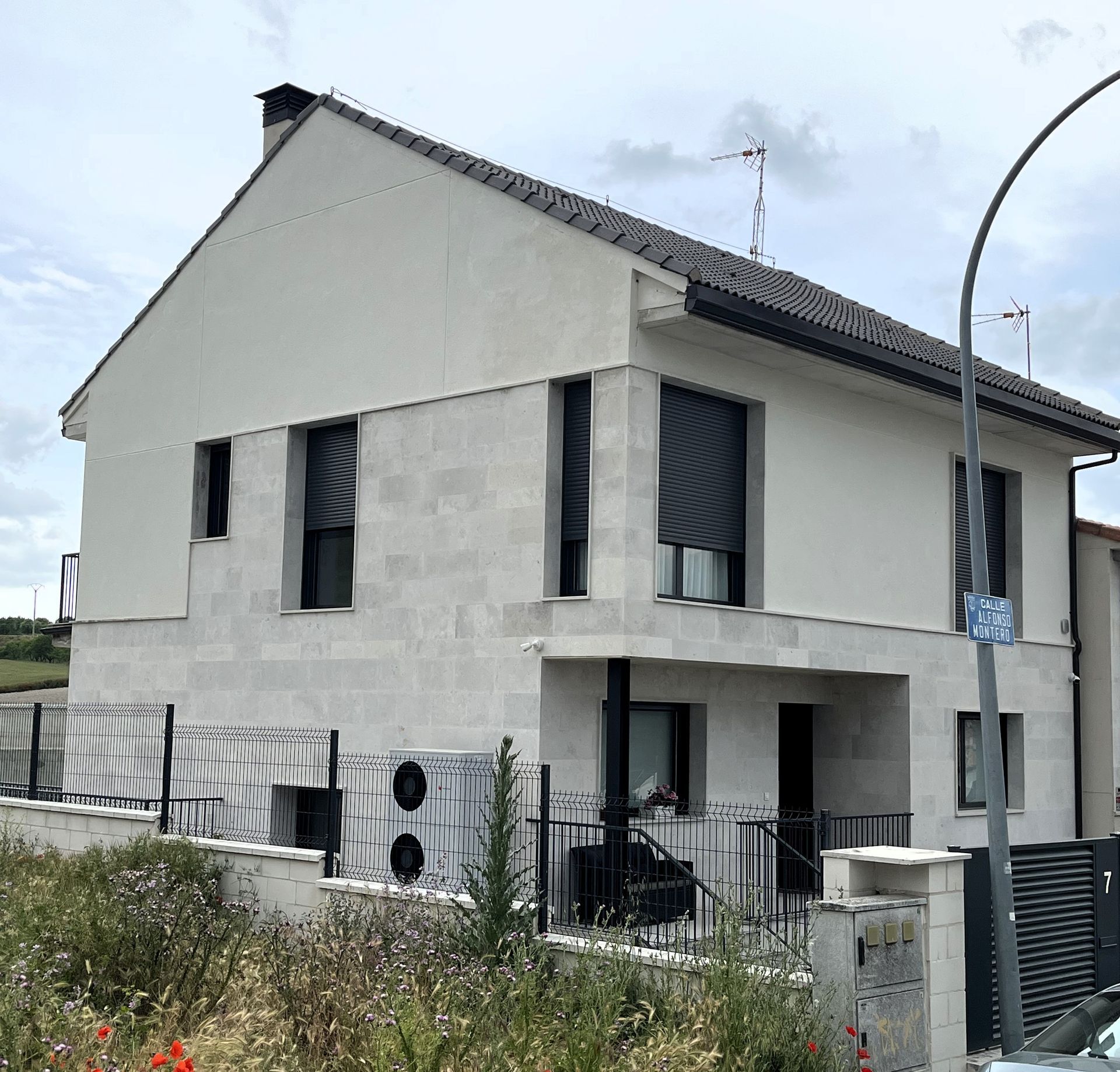 Una casa blanca con persianas negras en las ventanas