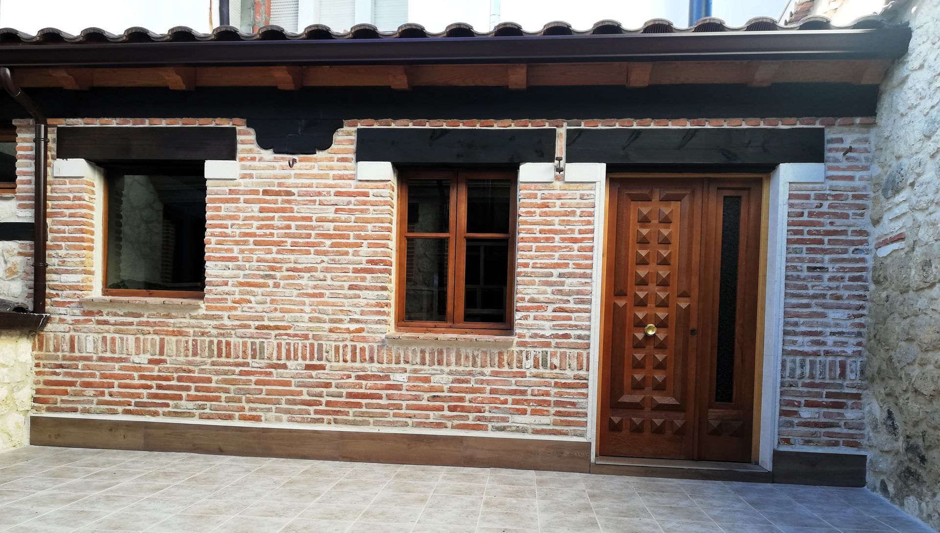 Un edificio de ladrillo con puerta y ventanas de madera