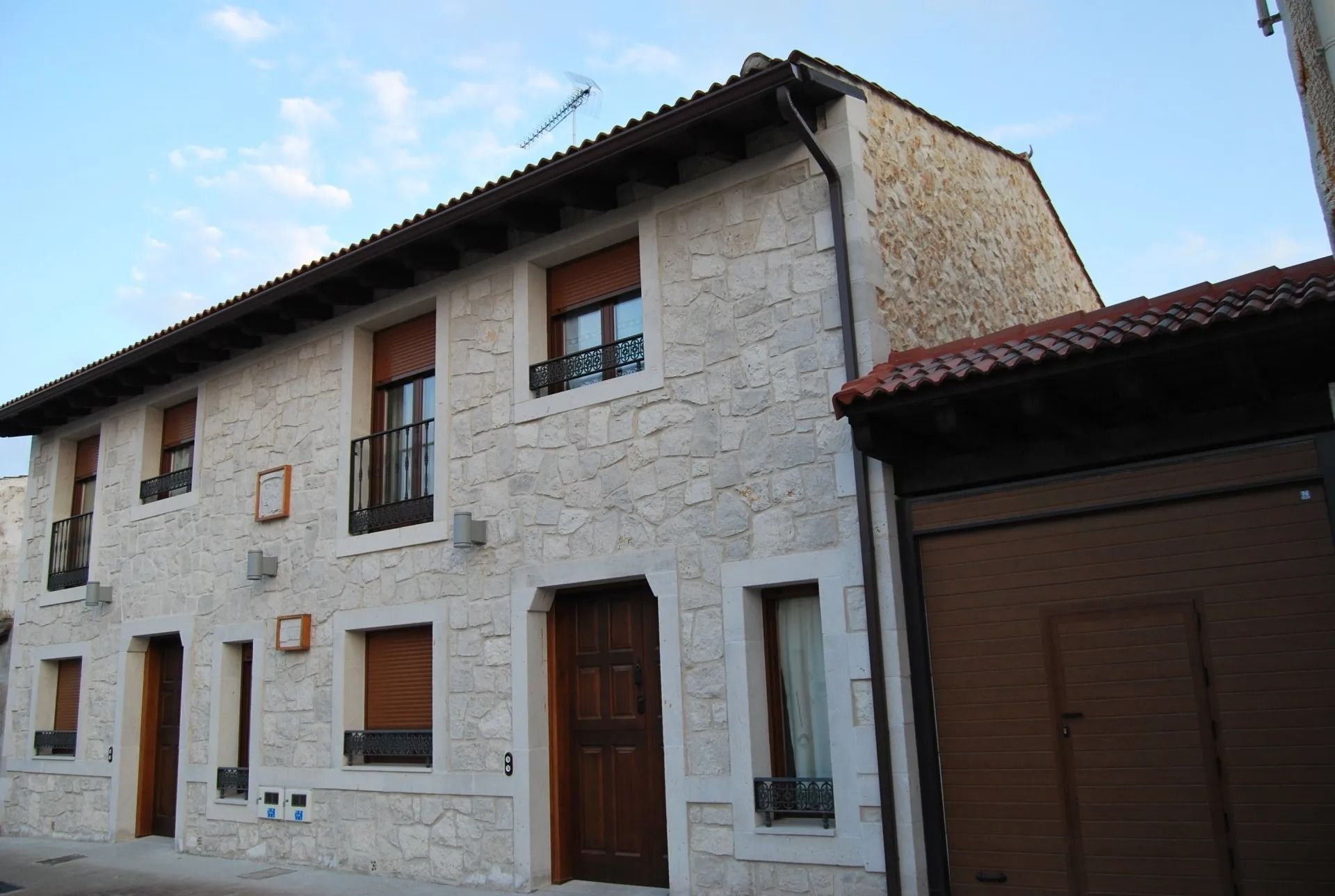 Un edificio de piedra con una puerta y ventanas marrones.
