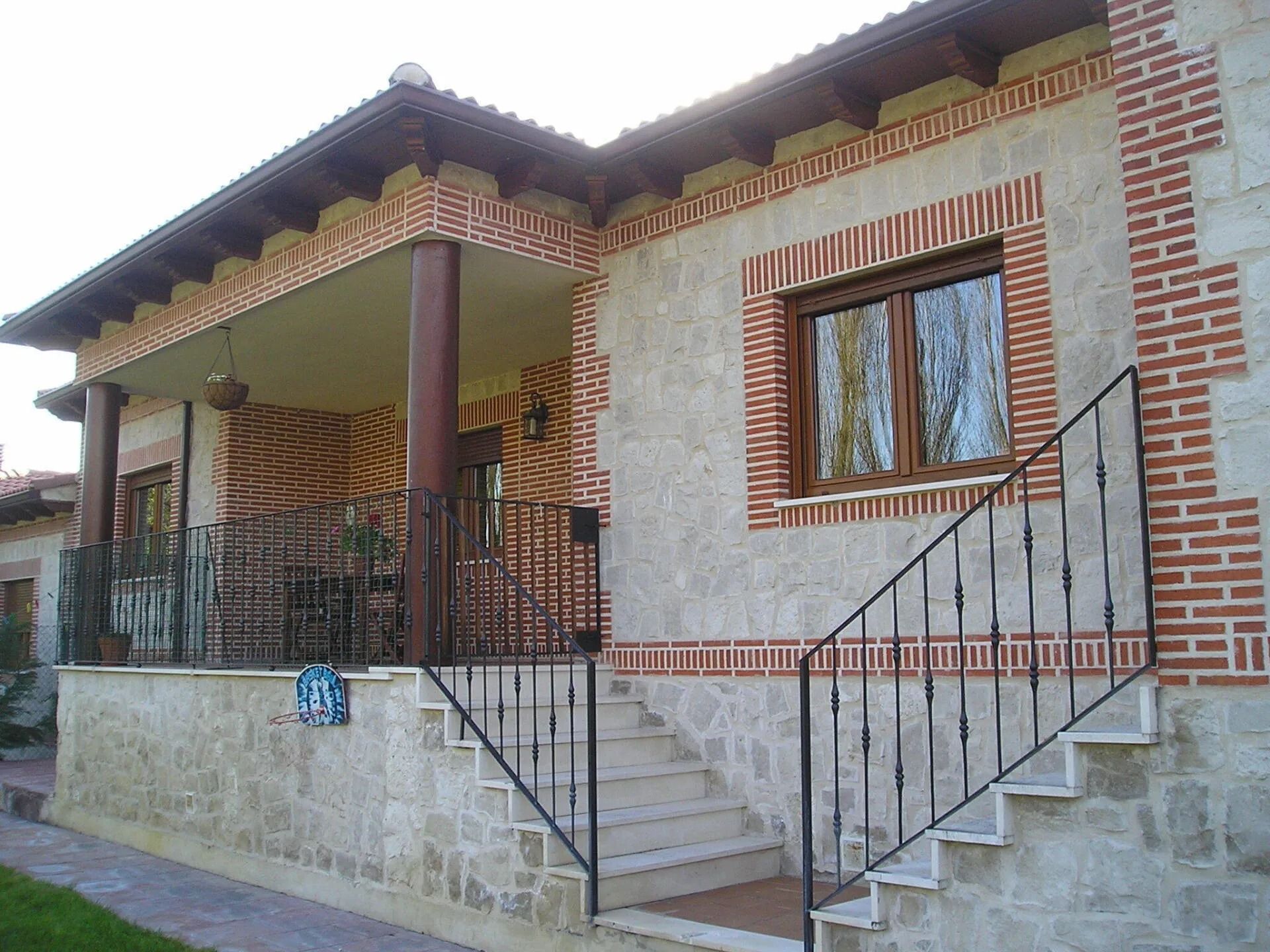 Una casa con un porche y escaleras que conducen a ella.