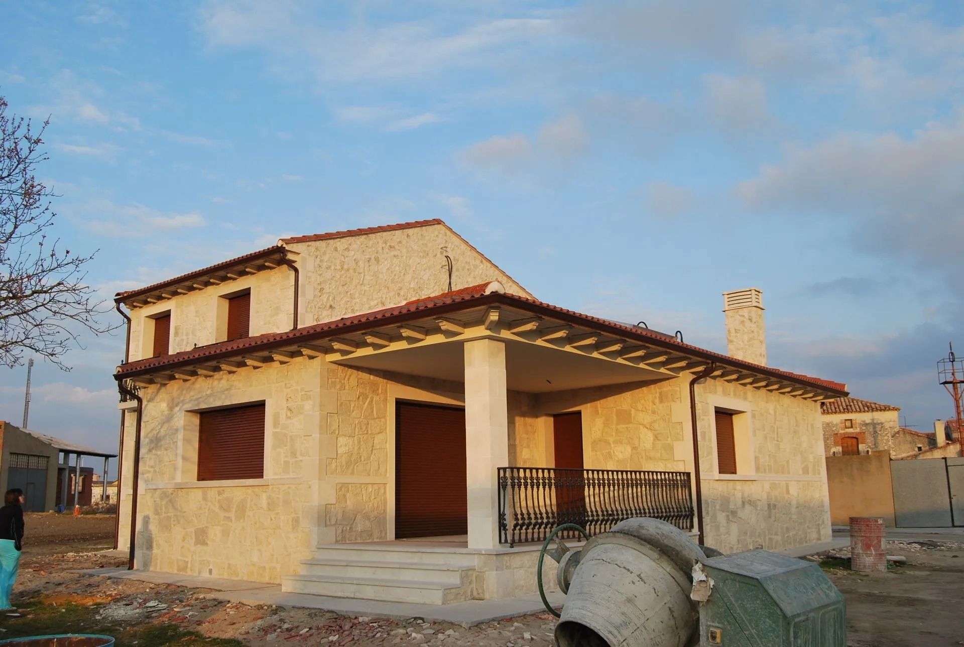 Una casa en construcción con una hormigonera delante de ella.