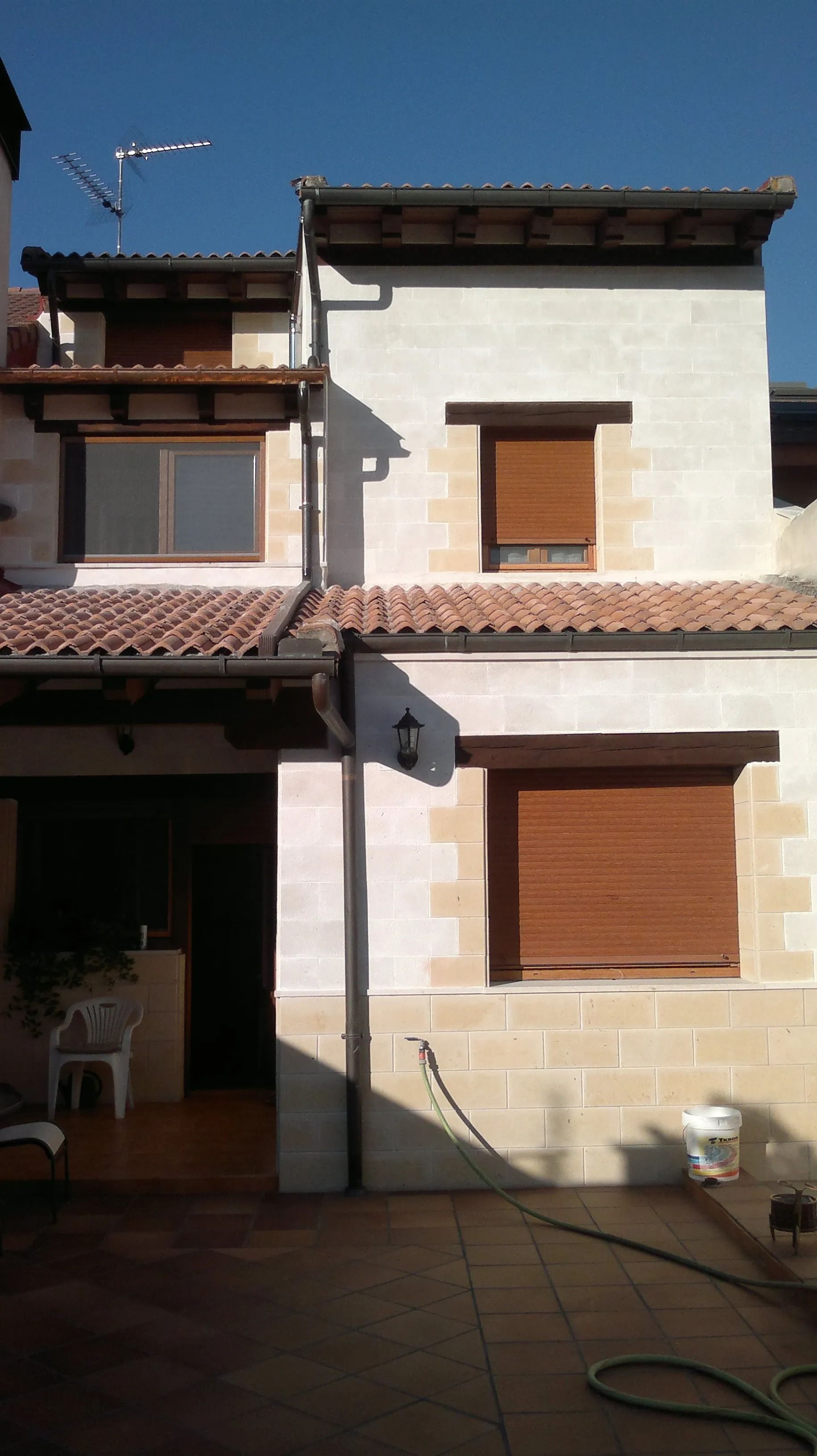 Una casa blanca con persianas marrones en las ventanas