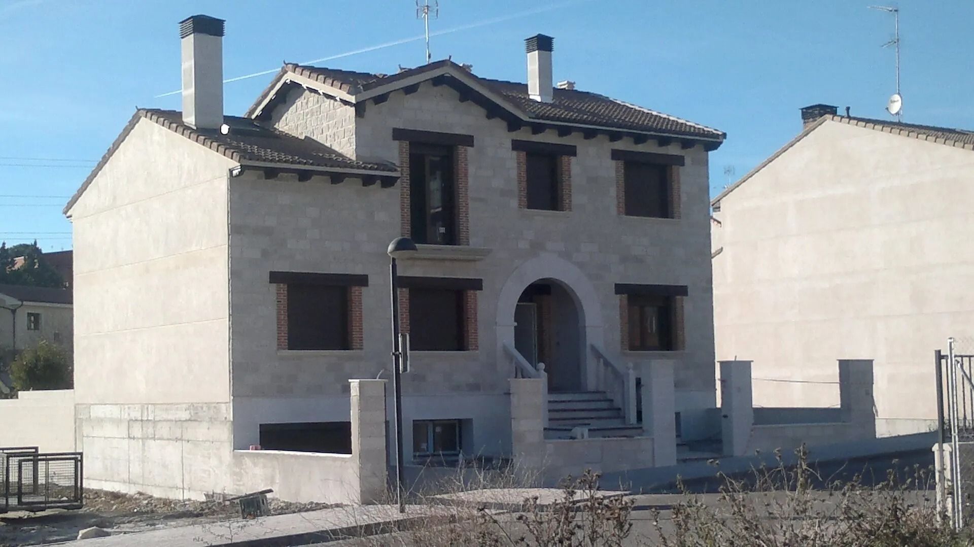 Una casa que se está construyendo con muchas ventanas y chimeneas