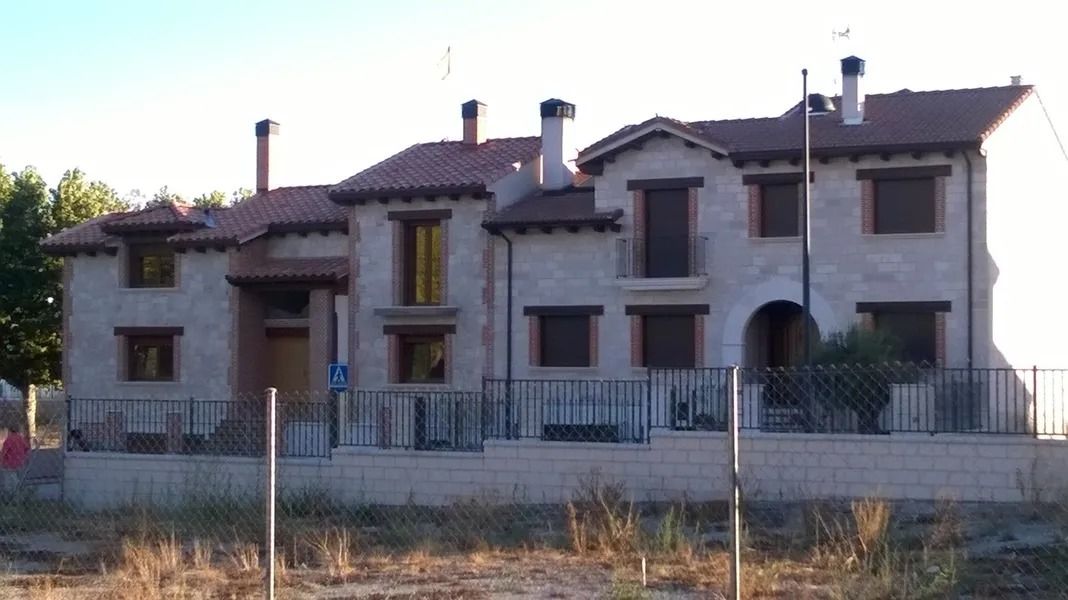 Una casa grande con muchas ventanas y chimeneas
