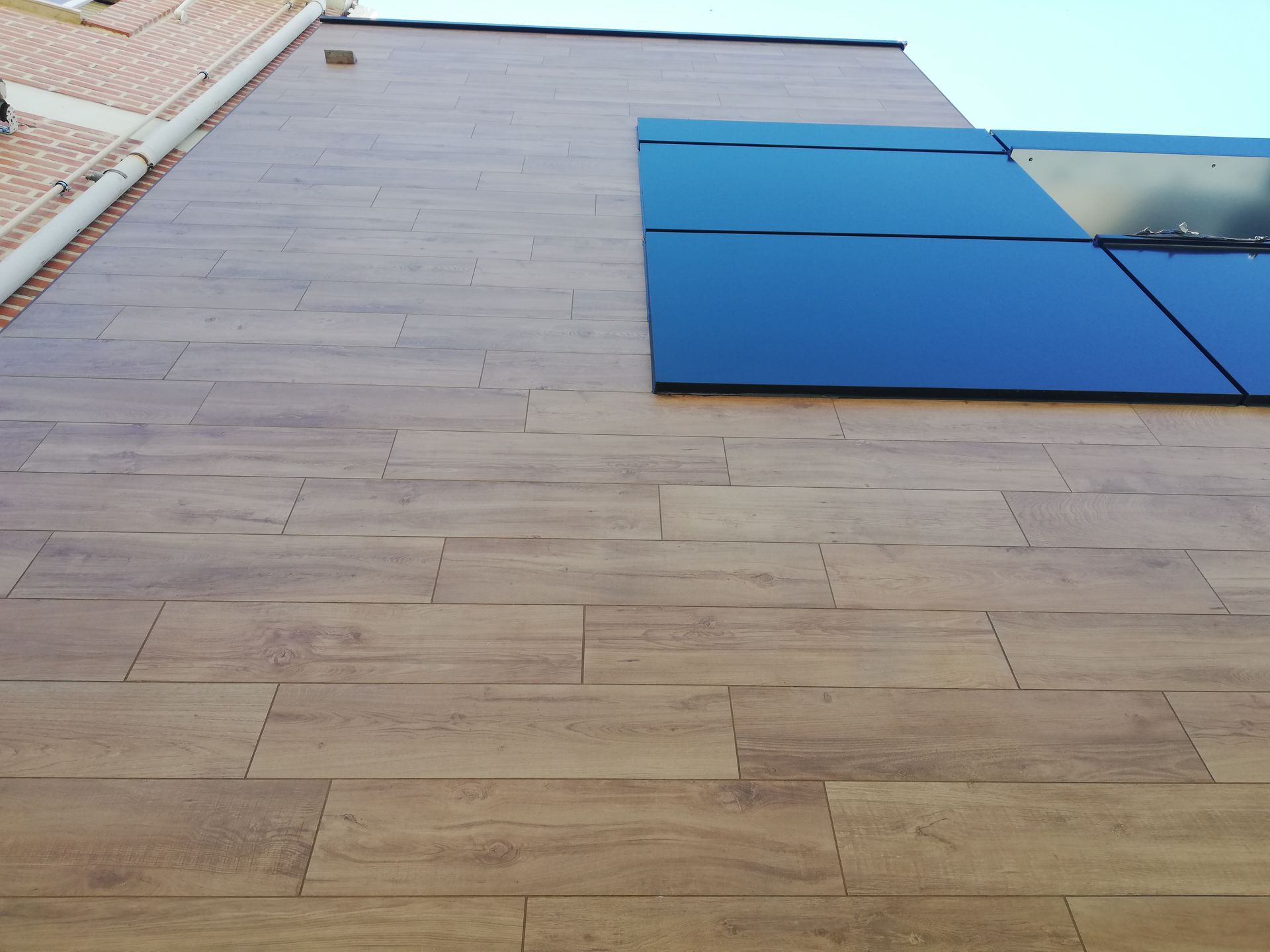 Un edificio con suelo de madera y una ventana azul.