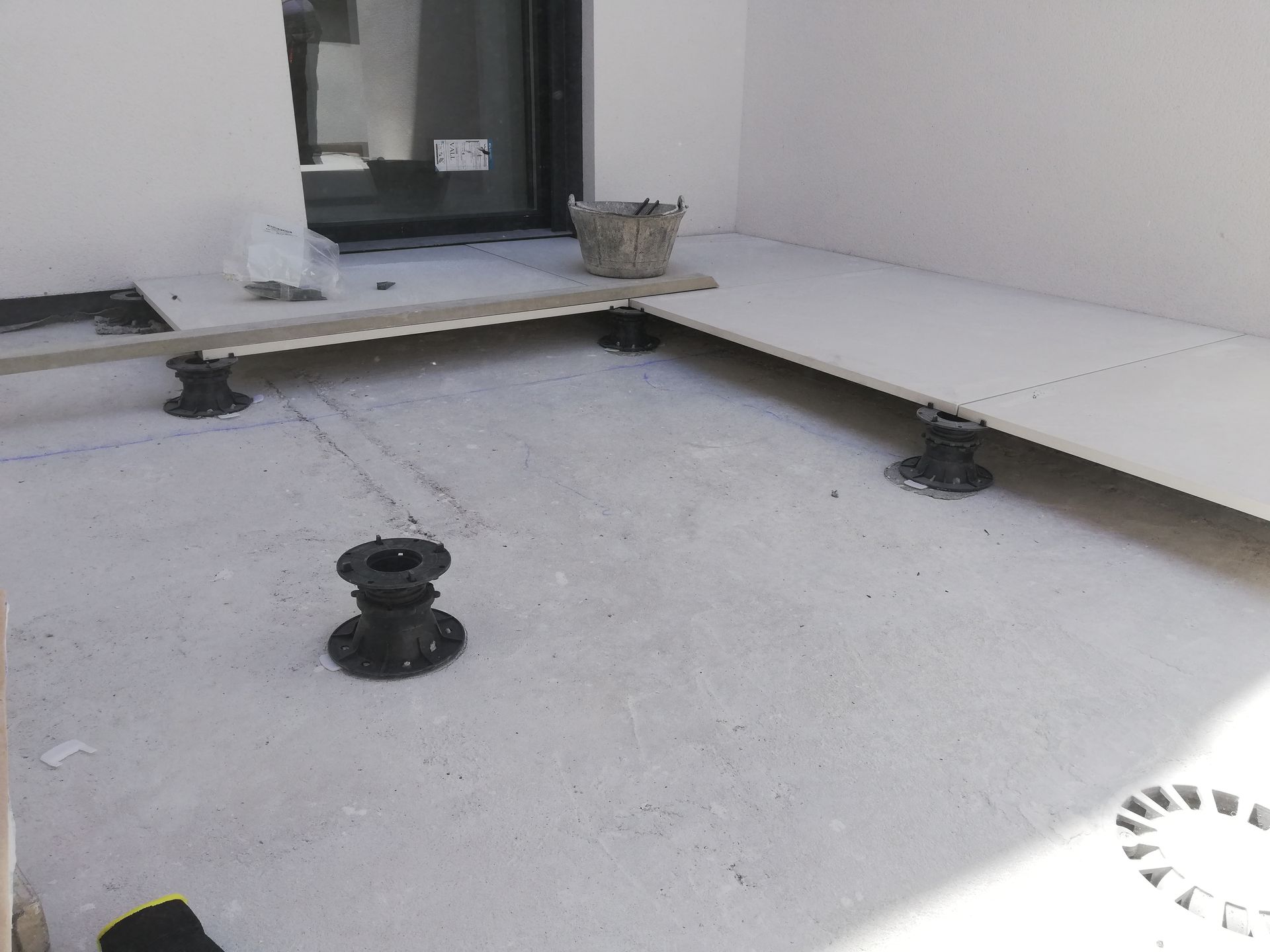 Un piso de concreto con un cubo encima.