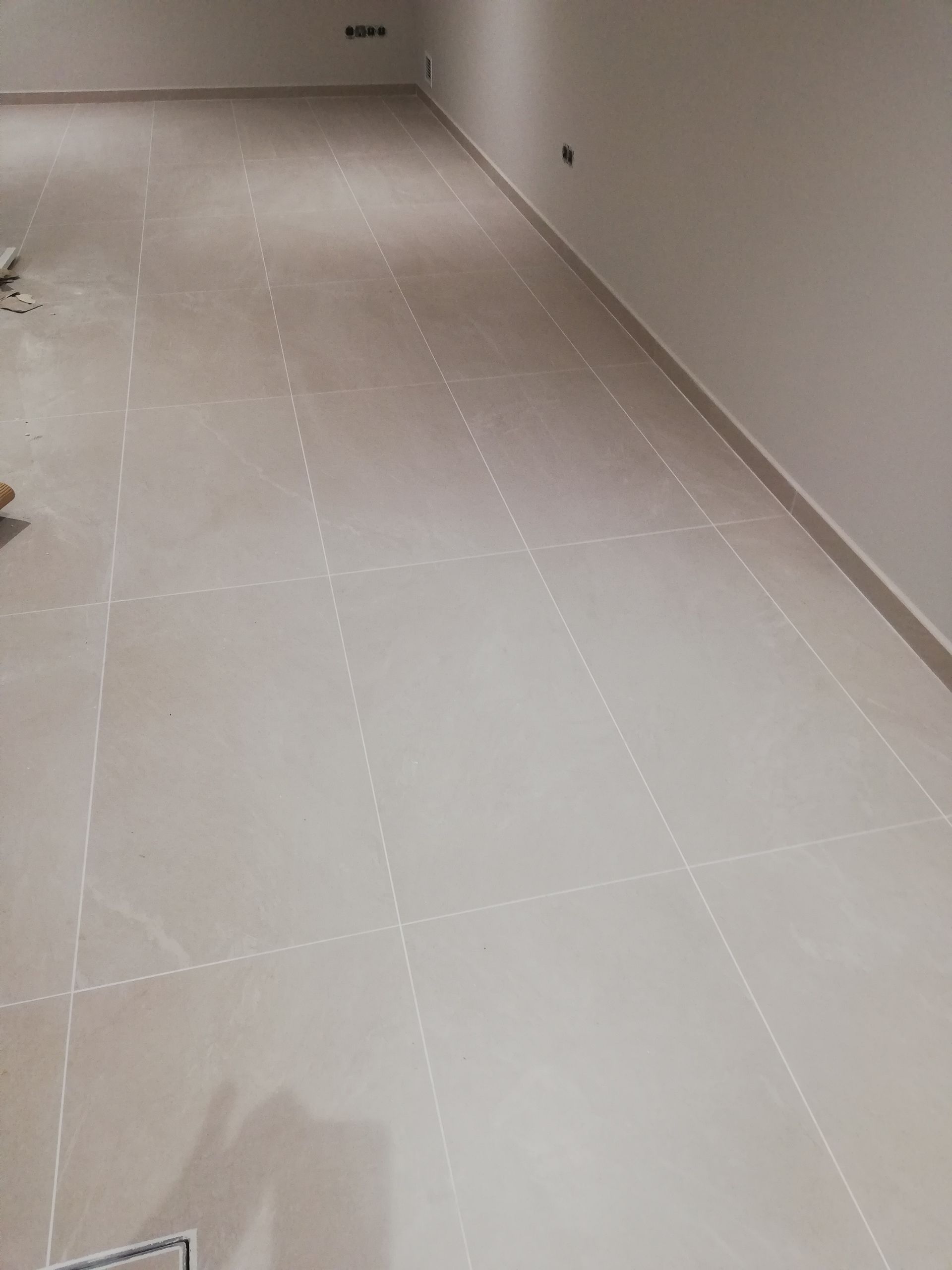 Un suelo de baldosas blancas en una habitación con paredes blancas.