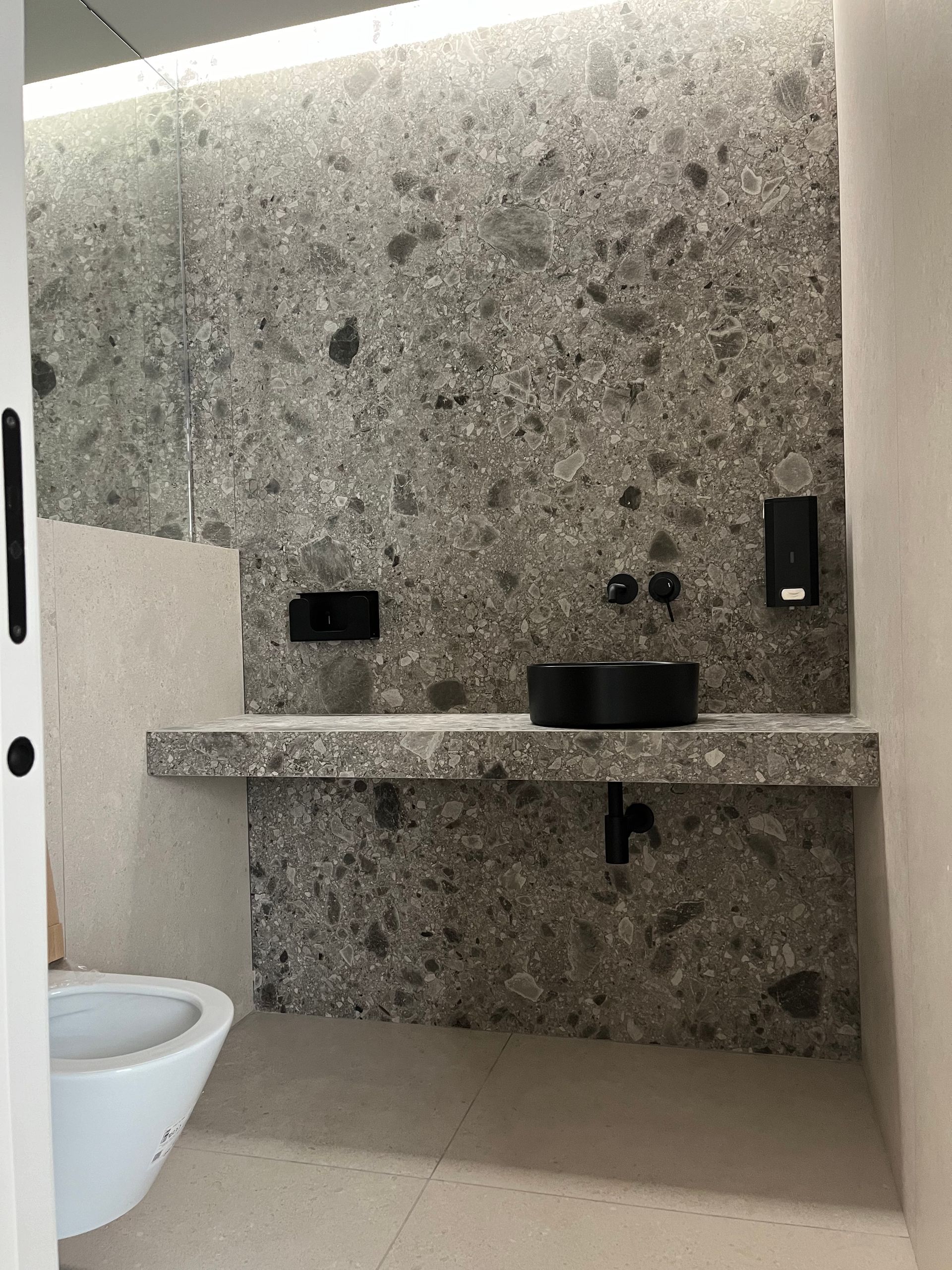 Un baño con inodoro, lavabo y espejo.