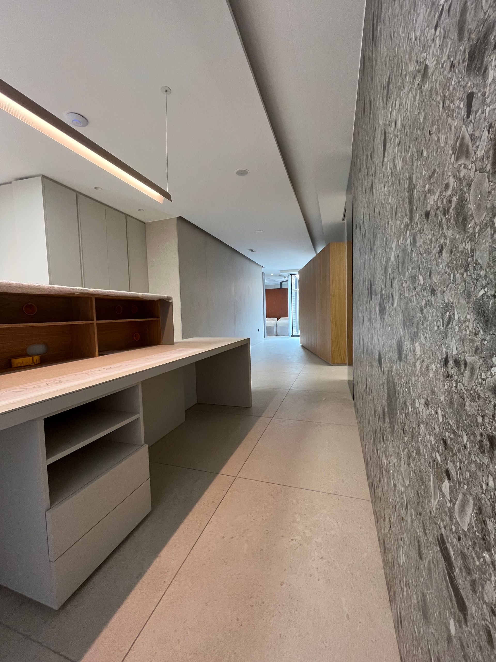 Un largo pasillo con un escritorio en el medio.