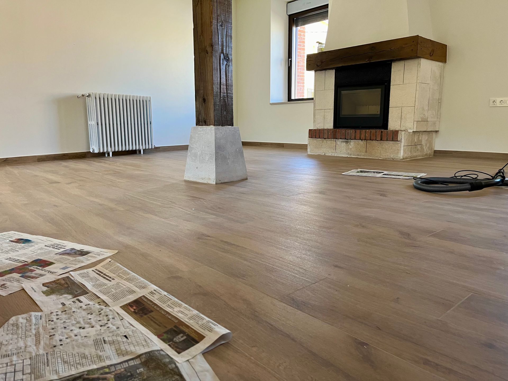 Una sala de estar con chimenea y un periódico en el suelo.