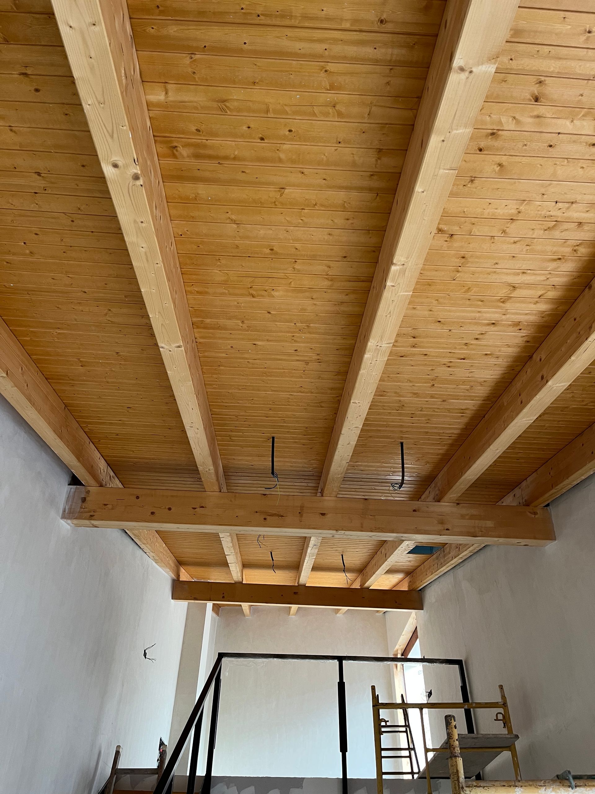 Una habitación con techo de madera y escaleras.