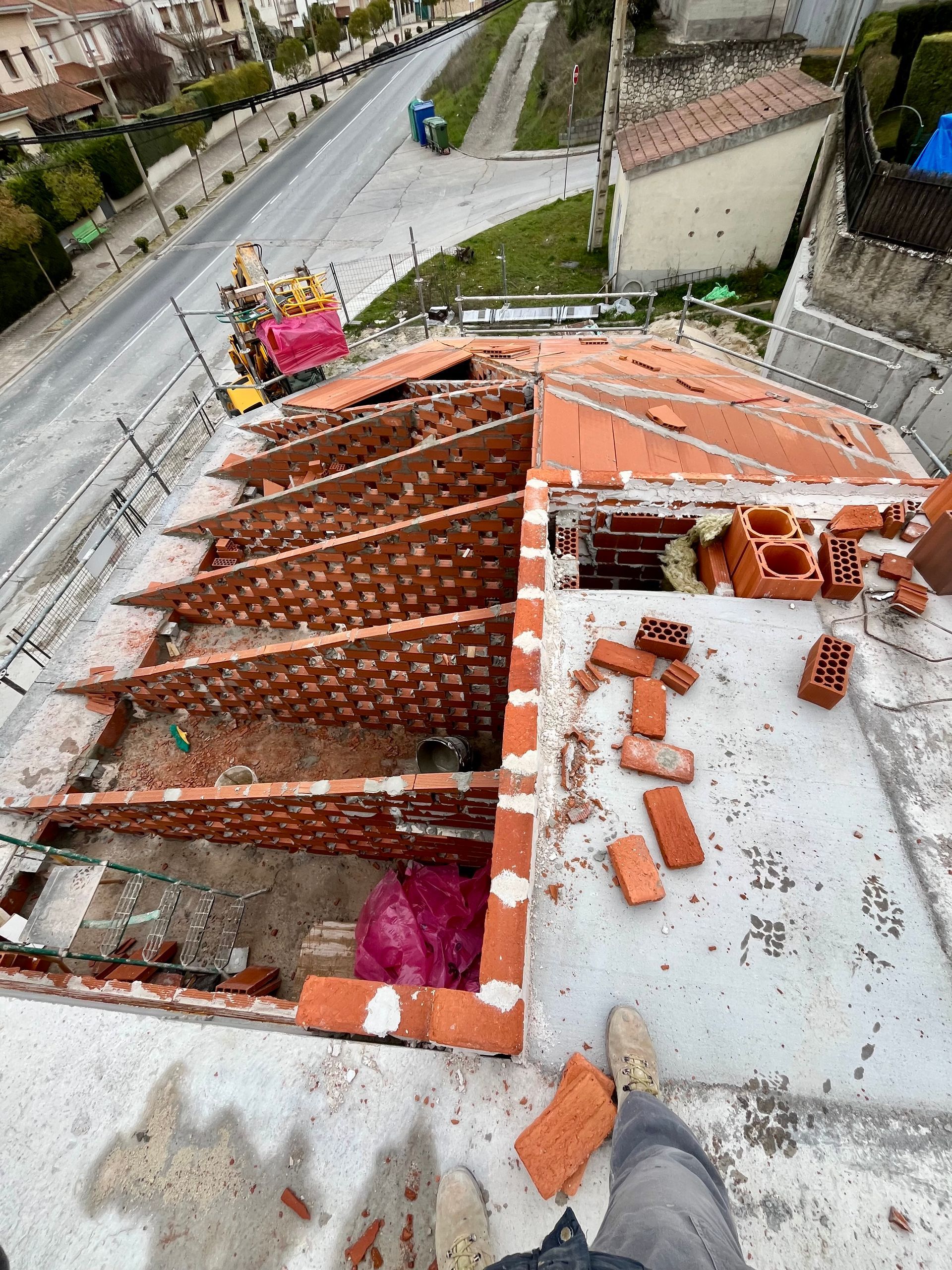 Una persona está parada en el techo de un edificio con ladrillos encima.