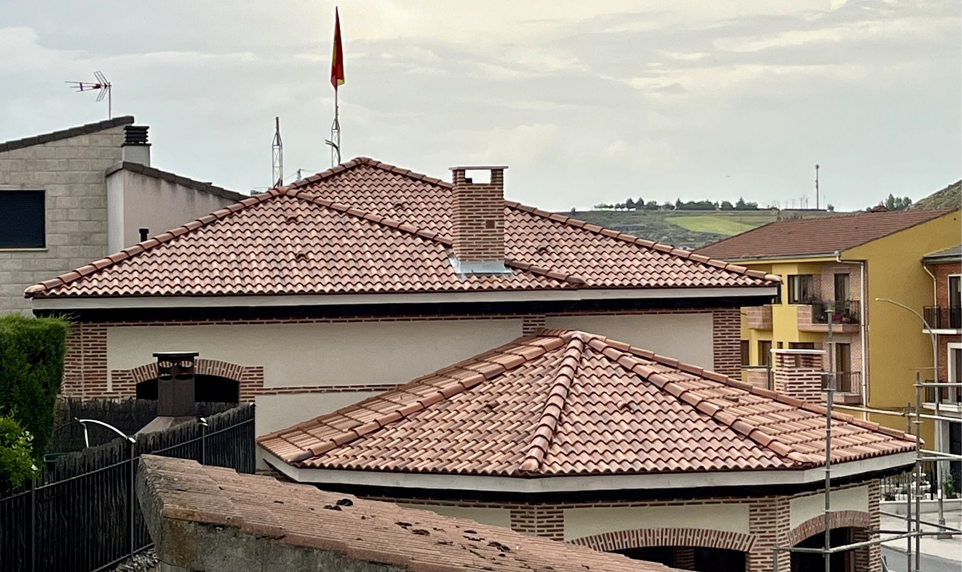 Una casa con techo de tejas tiene una bandera encima.
