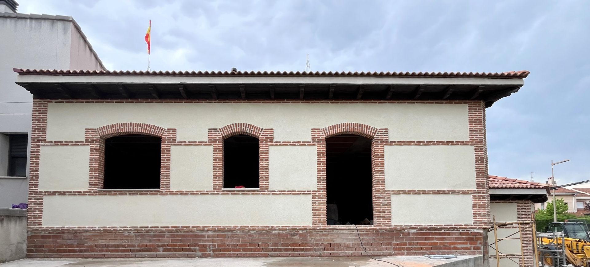 Un edificio en construcción con una pared de ladrillo y un techo.