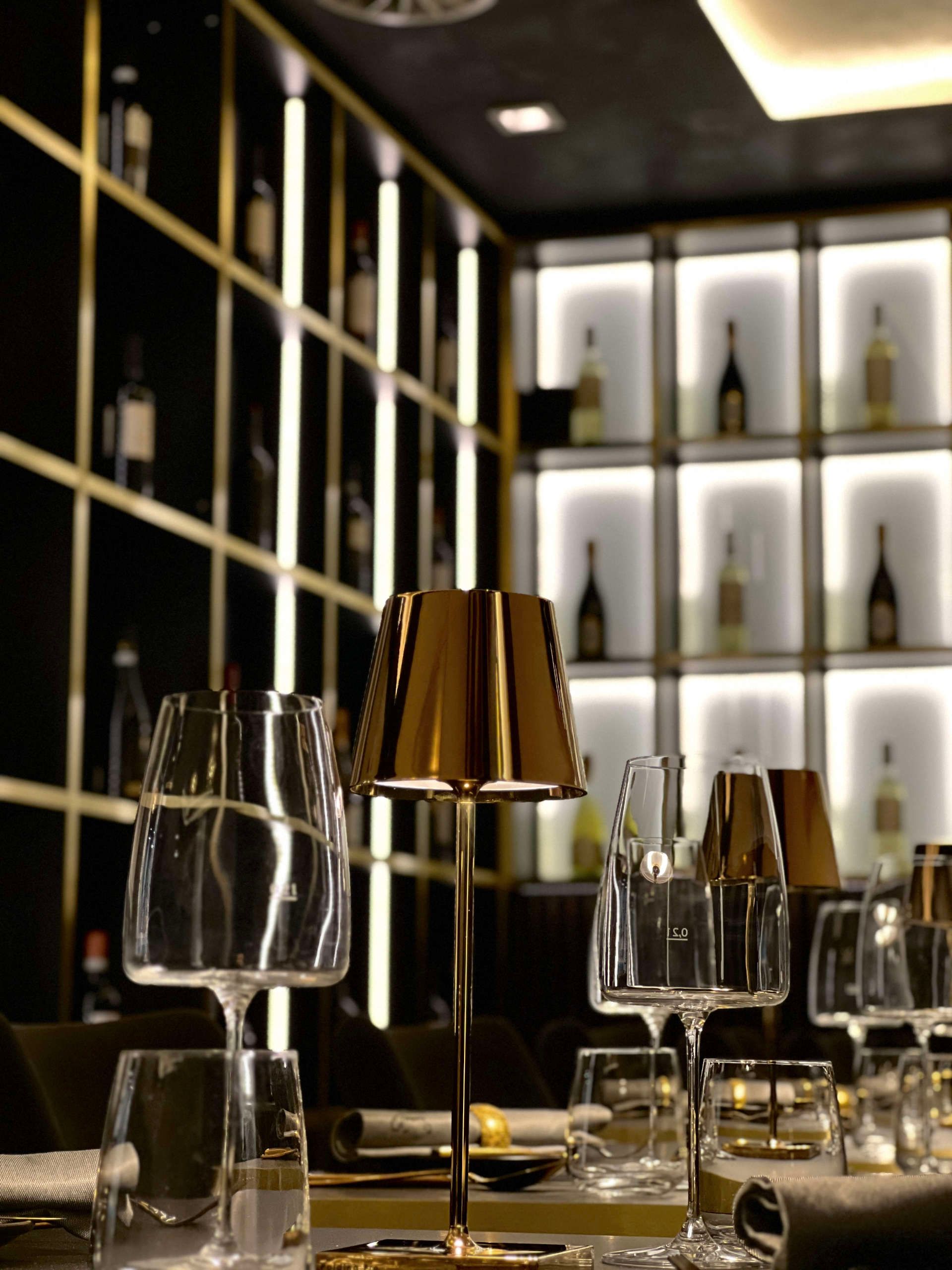 ein Tisch in einem Restaurant mit Gläsern und einer Lampe