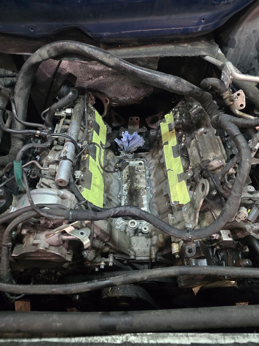 Ein Mechaniker in Arbeitskleidung schüttelt einem Kunden in einer Autowerkstatt die Hand.