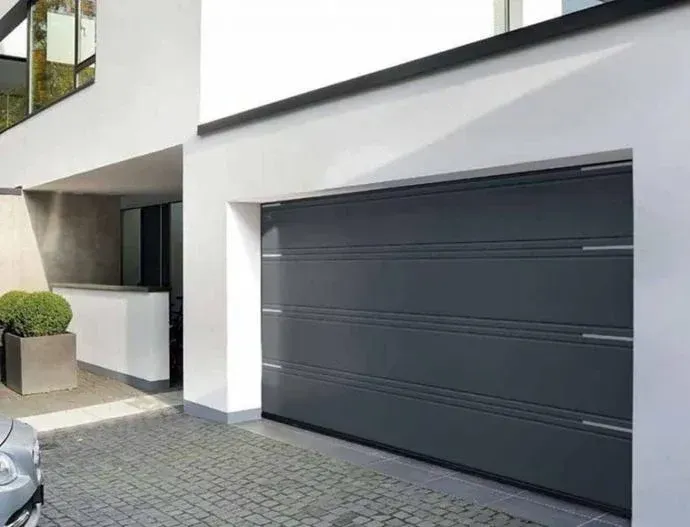 Persona con traje de protección rociando un sistema de pesticida montado en un vehículo sobre arbustos