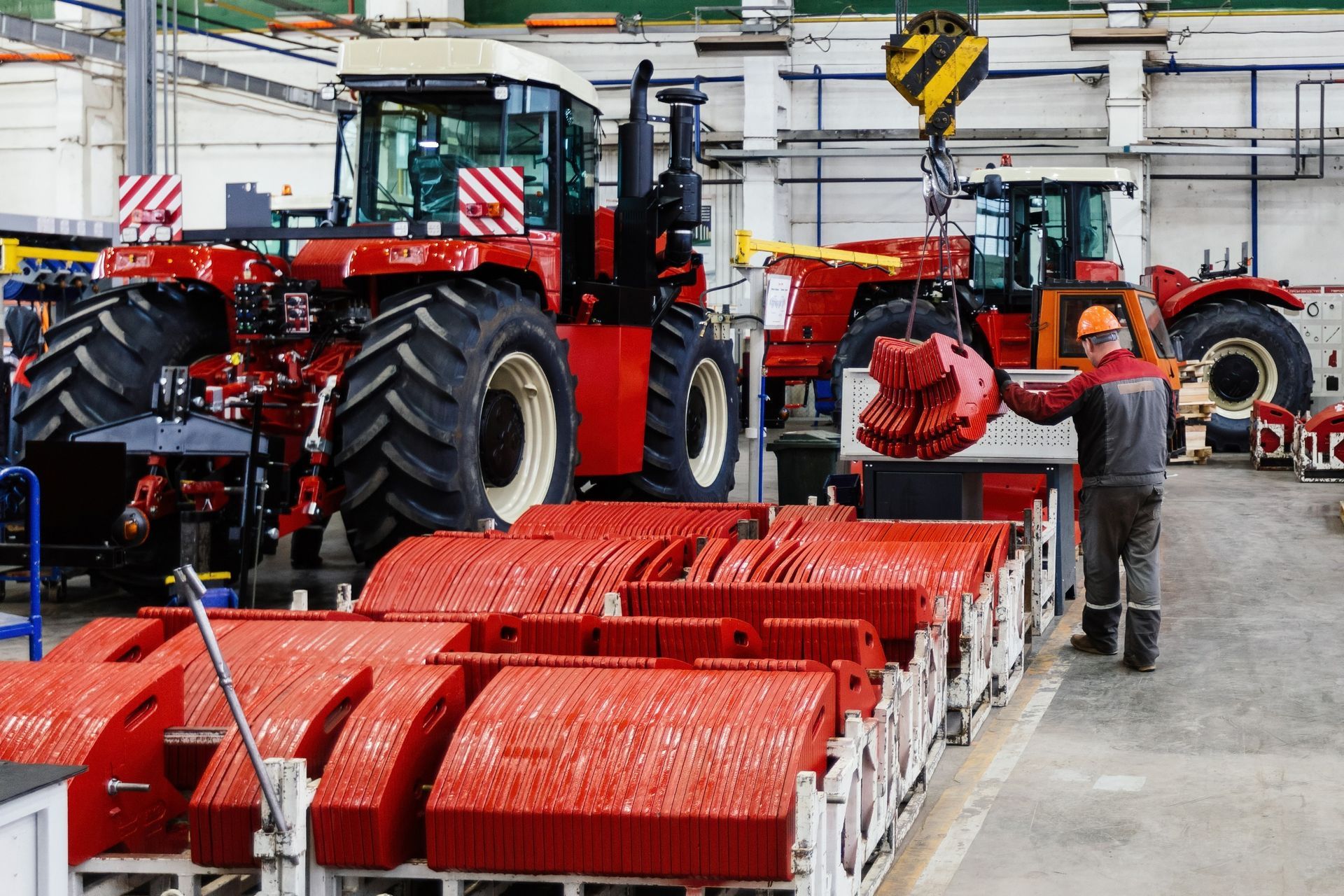 Un hombre está trabajando en un tractor en una fábrica.