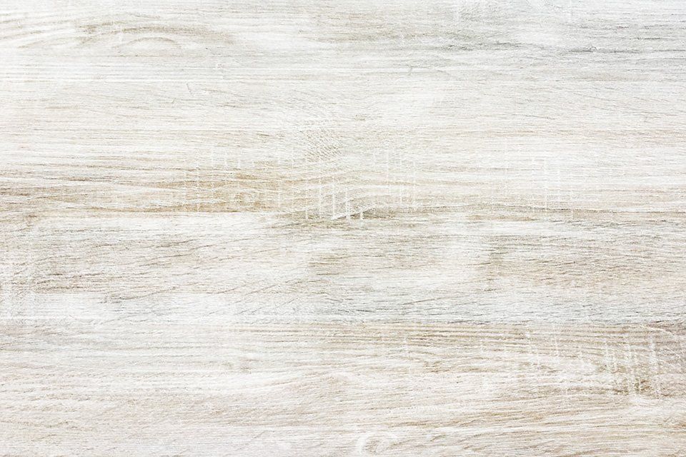 Gros plan d'une planche de bois cérusée blanche.