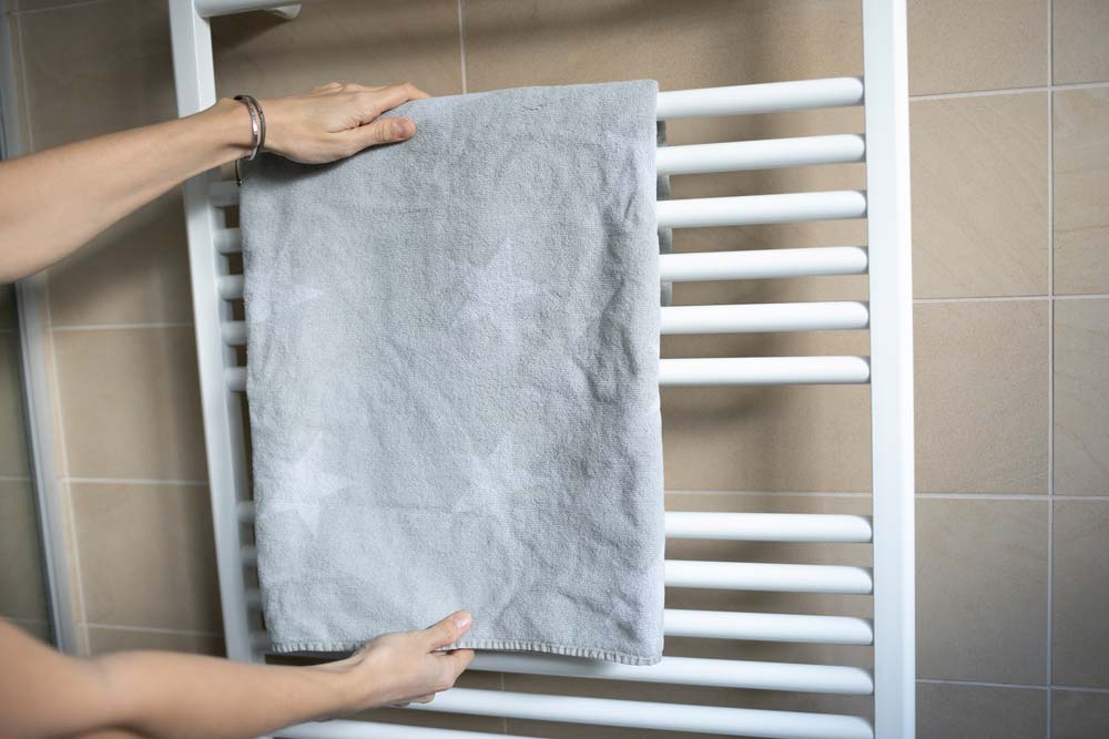 Sèche-serviettes avec une serviette grise dessus