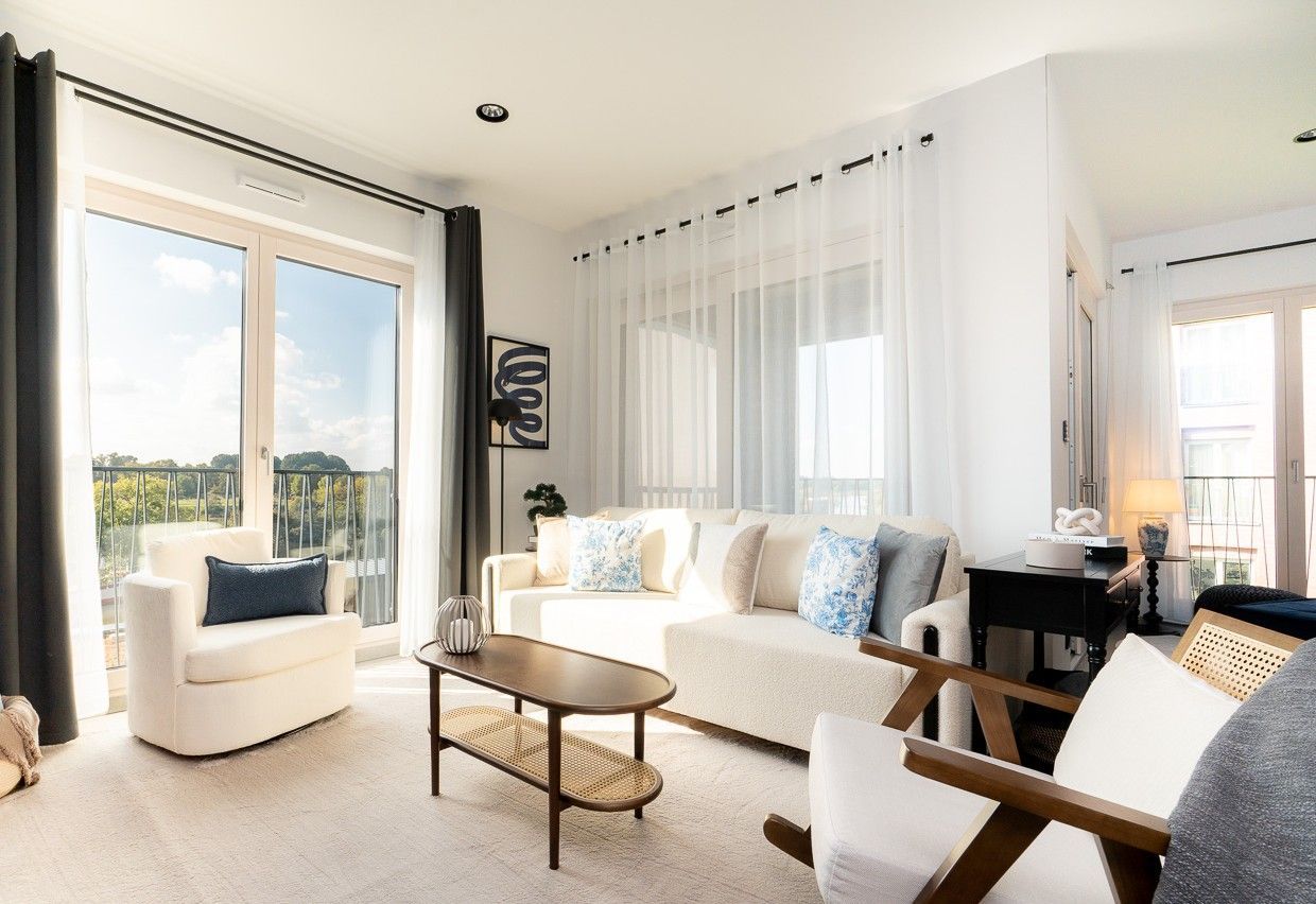 Heller Wohnbereich einer Ferienwohnung in Dresden mit großer Fensterfront, Sofa und modernem Wohnkonzept