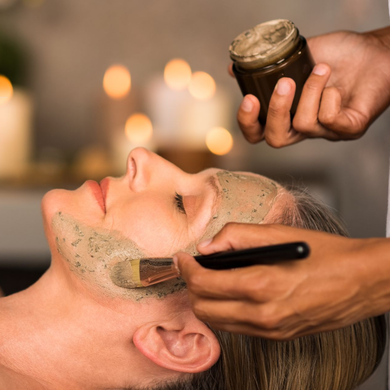 Personne en train d'appliquer un masque sur le visage d'une femme