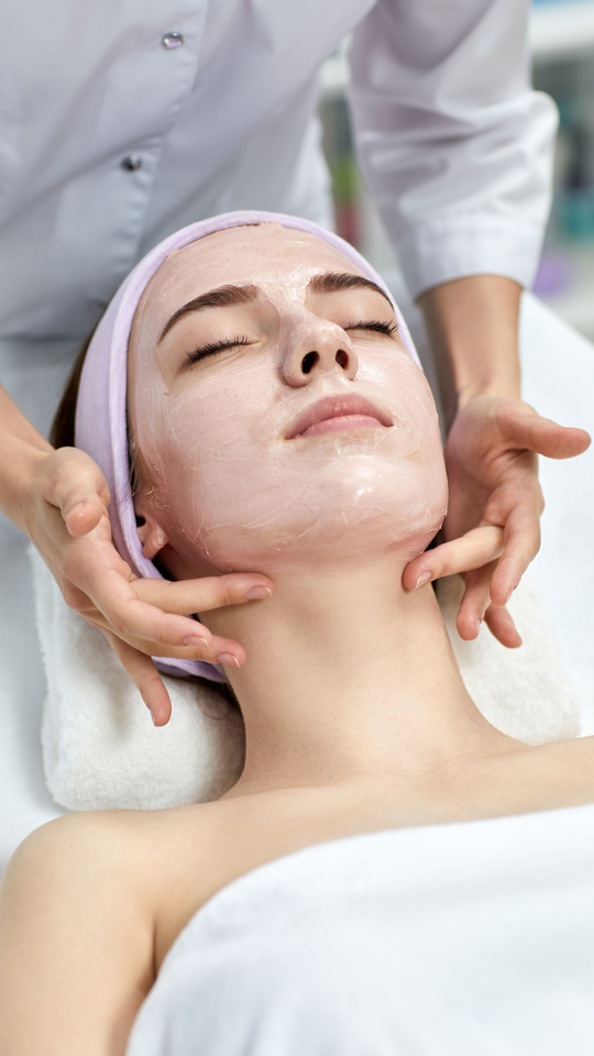 Personne avec un bandeau rose pendant un soin du visage