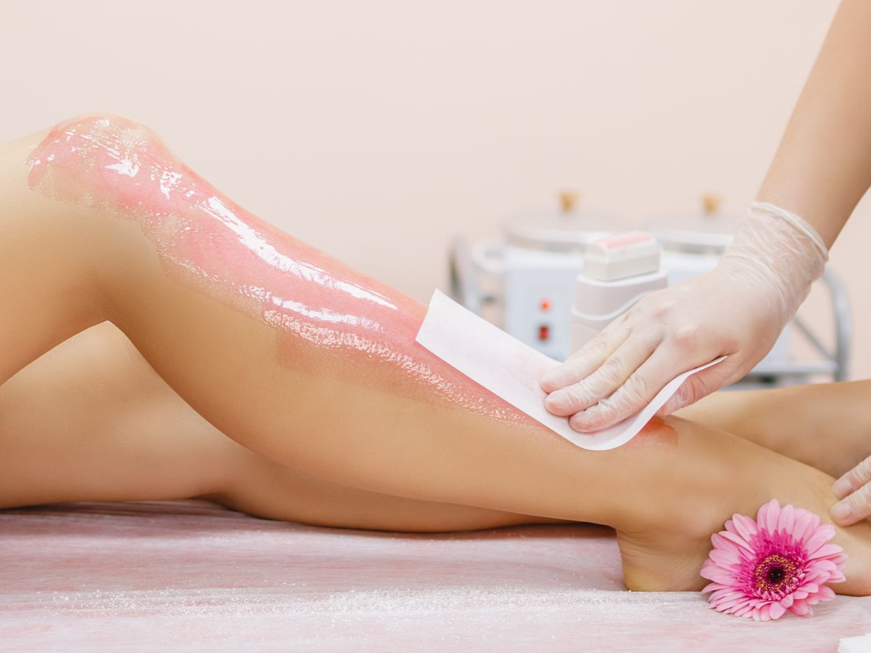 Épilation des jambes avec de la cire rose