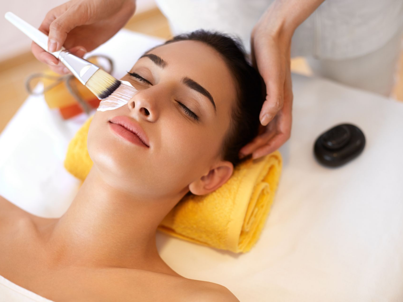 Femme avec la tête posée sur une serviette jaune