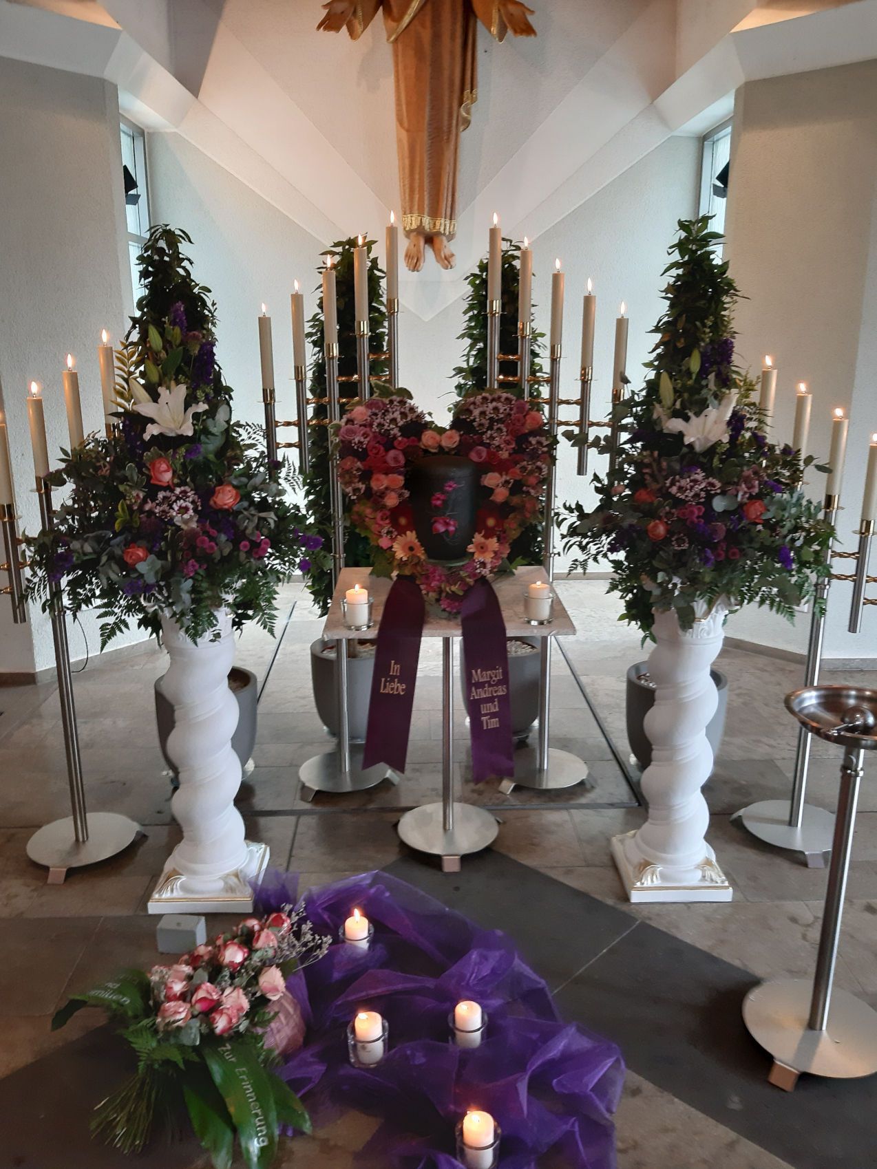Urnentrauerfeier mit Kerzen, Blumenschmuck und würdevoller Atmosphäre