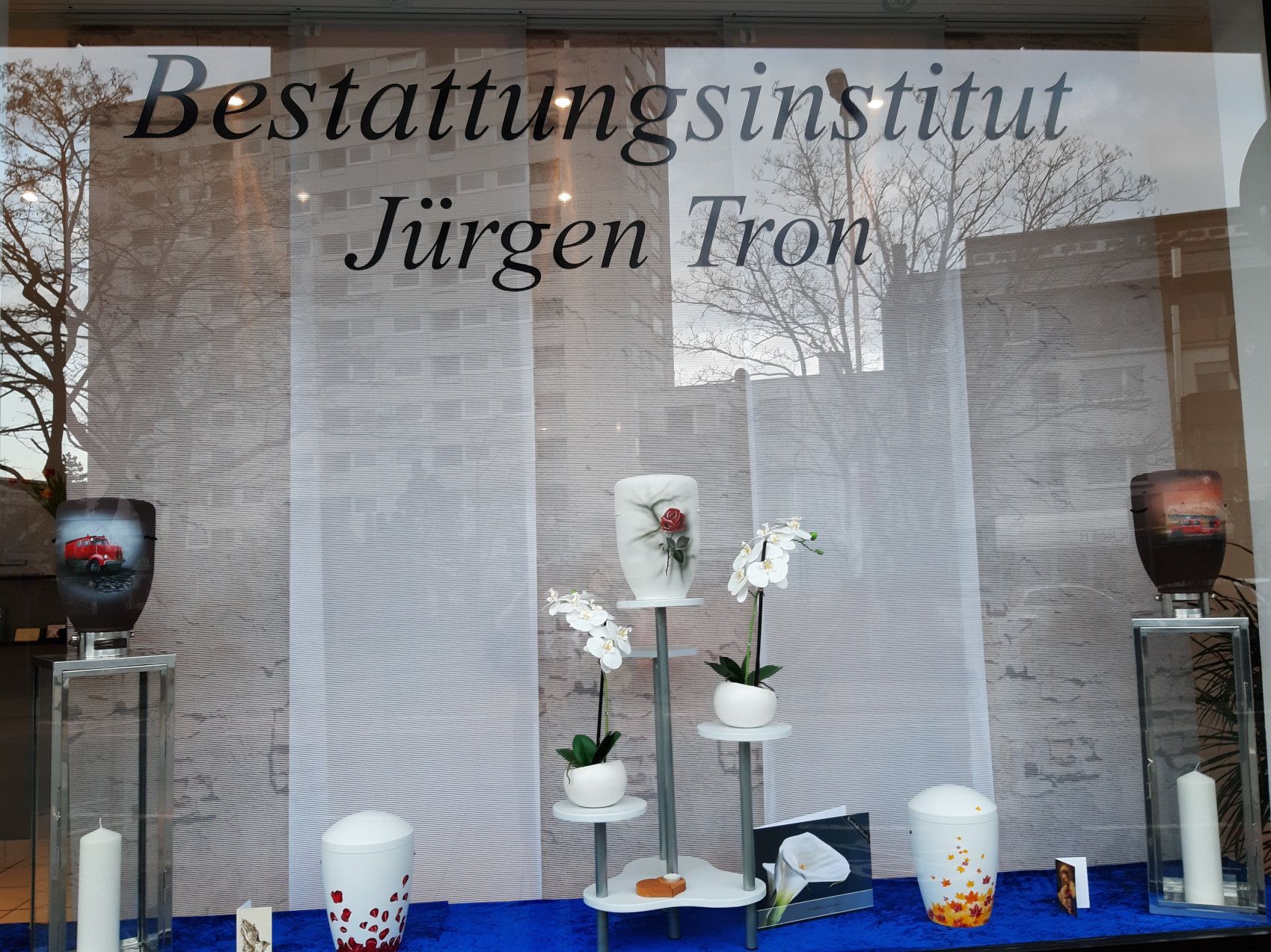 Schaufenster mit Urnenausstellung und stilvoller Trauerdekoration