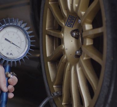 Voitures sur des ponts élévateurs dans un atelier de réparation automobile ; outils et équipements visibles.