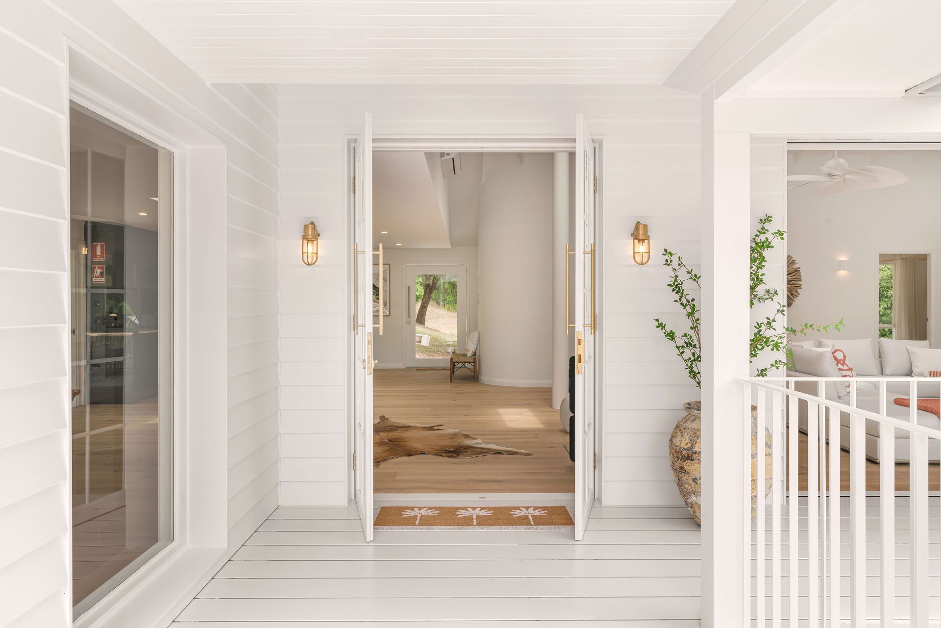 A white house with a porch and a door that is open.