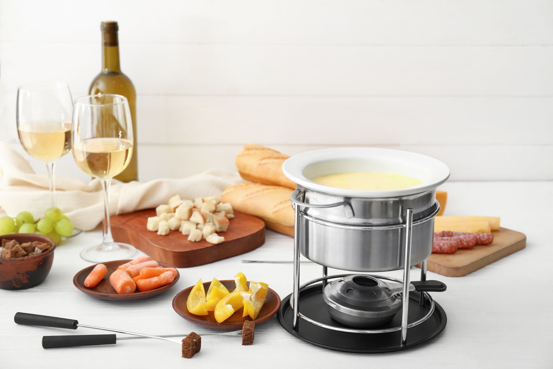 Deux ouvriers installent des meubles de cuisine dans une cuisine lumineuse, l'un sur une échelle et l'autre accroupi avec des outils.