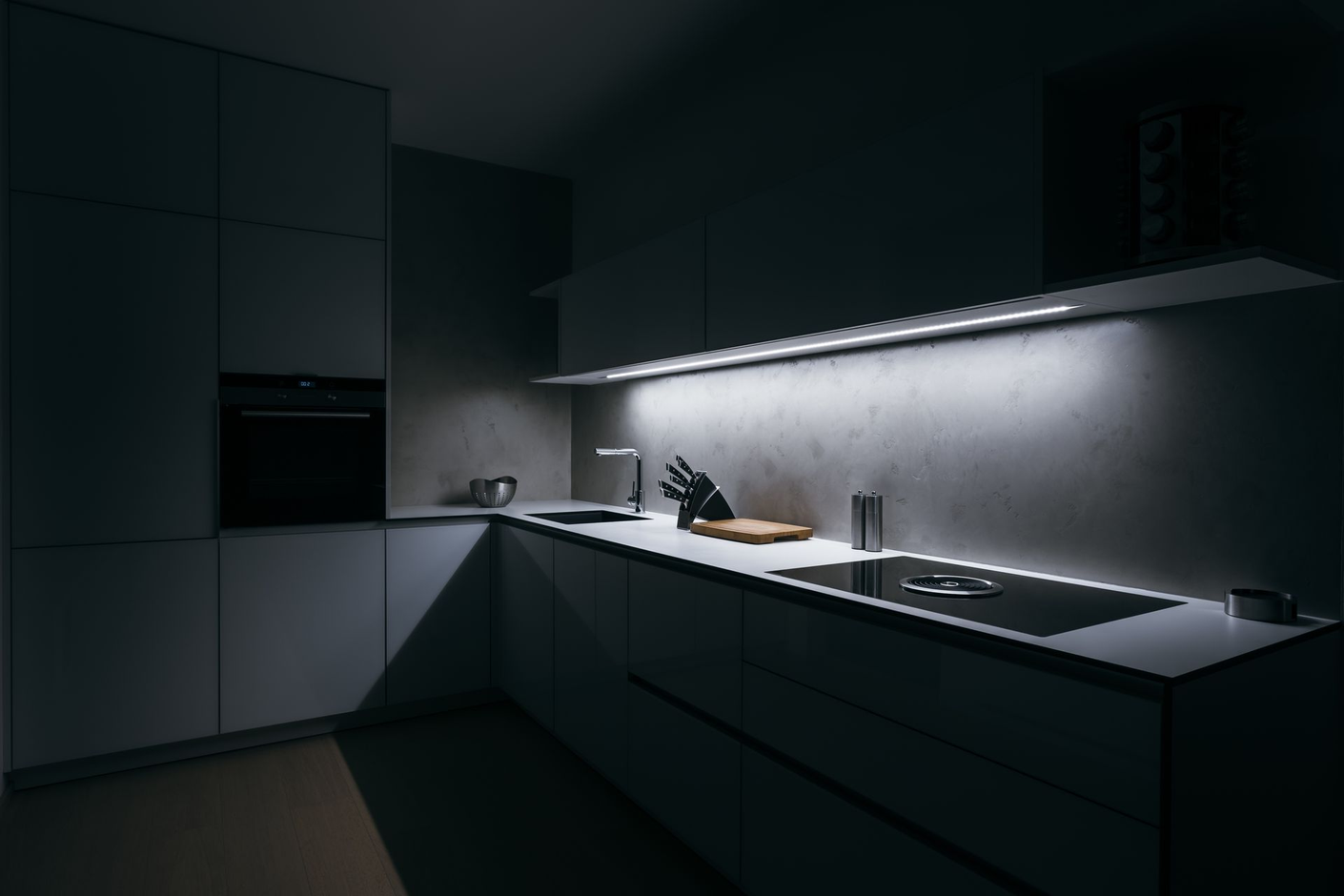 Cuisine moderne sombre avec un comptoir, un évier et un éclairage sous les armoires aux lignes épurées.