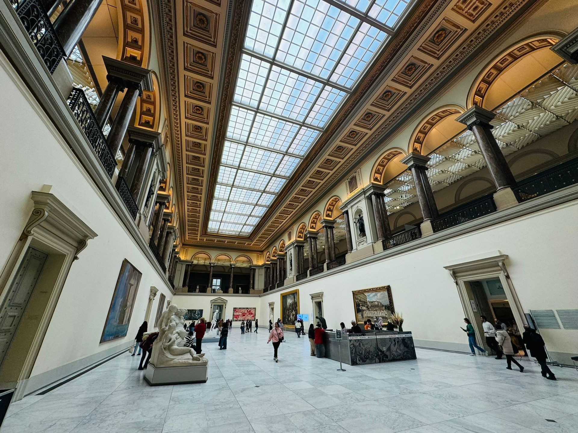 A large room with a glass ceiling and people walking around