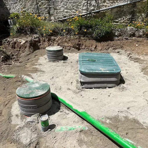 Installation d'un système d'assainissement individuel avec regards et canalisations enterrées.