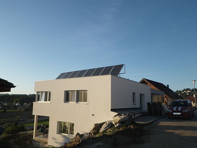 Ein weißes Haus mit Solarzellen auf dem Dach