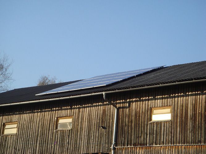 Ein Holzgebäude mit Solarmodulen auf dem Dach