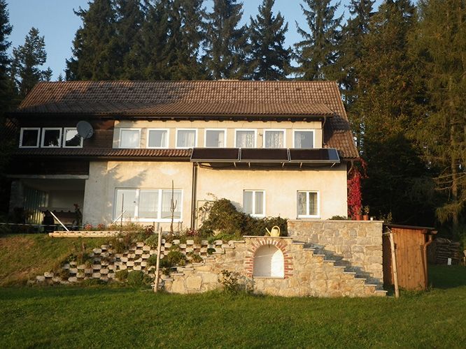 Ein Haus mit Treppen, die hinaufführen, ist von Bäumen umgeben