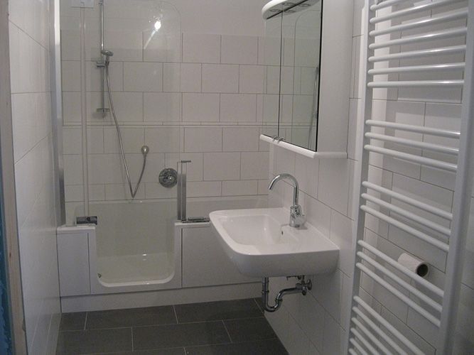 Ein Badezimmer mit Waschbecken, Dusche und Handtuchhalter.