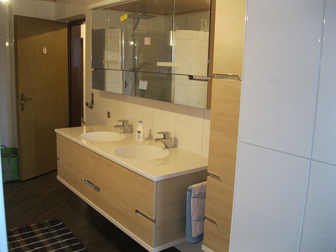 Ein Badezimmer mit zwei Waschbecken und einem Spiegel.