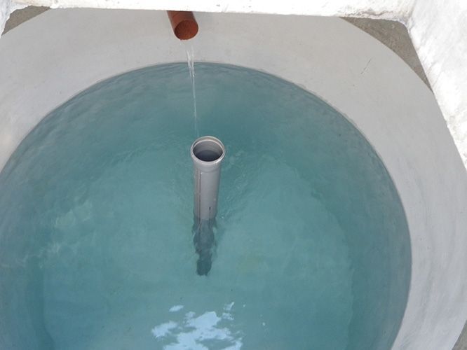 Ein Rohr kommt aus einem Loch in der Mitte eines Wasserbeckens.