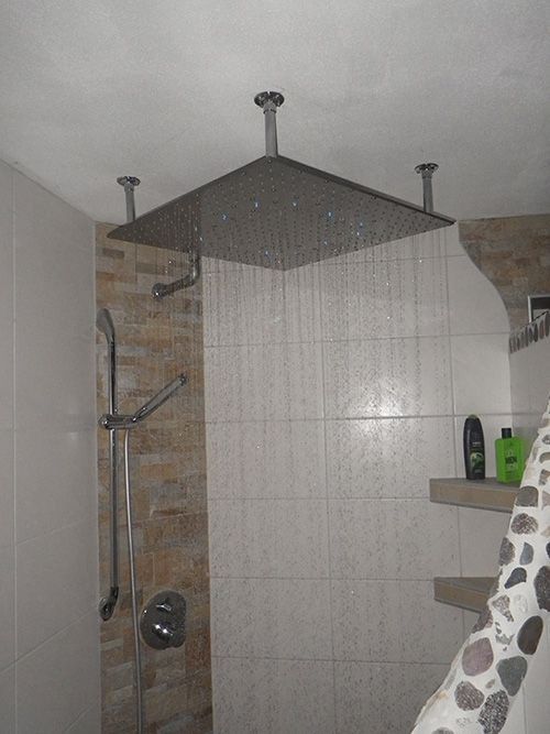 In einem Badezimmer hängt ein Duschkopf von der Decke.